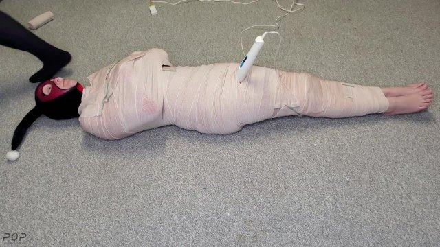 Harley Quinn wrapped in layers of mummification bondage then teased with a wand & made to cum