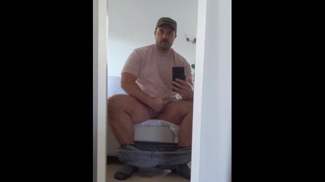 Rugged bear wearing baseball cap wanks and blows on mirror